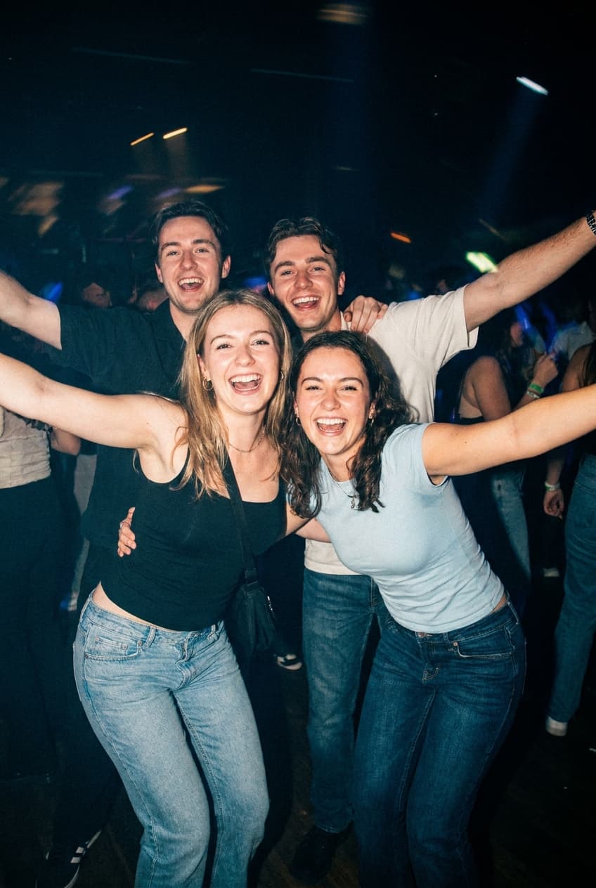 Vrienden feesten in een club met blauwe lichten
